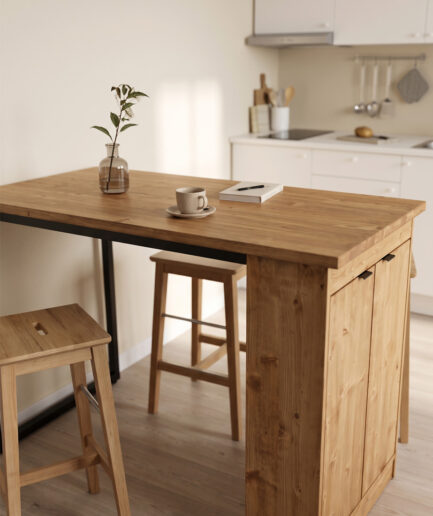 Wooden kitchen island with two stools, a cup on a saucer, and a notebook beside a small vase of greenery in a bright, white kitchen setting the warm tone of the space.
