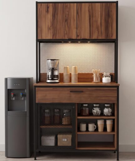 Coffee station built into a wooden cabinet with a drip coffee maker, cups, and jars on the counter under a metal grid backsplash, plus a water dispenser to the left.